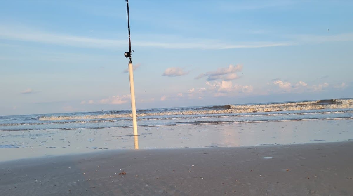 Surf rod in a sand spike at the water's edge on a Texas beach